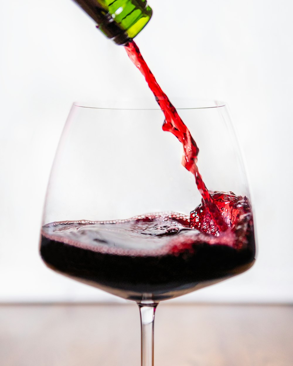 verre à vin transparent avec du vin rouge