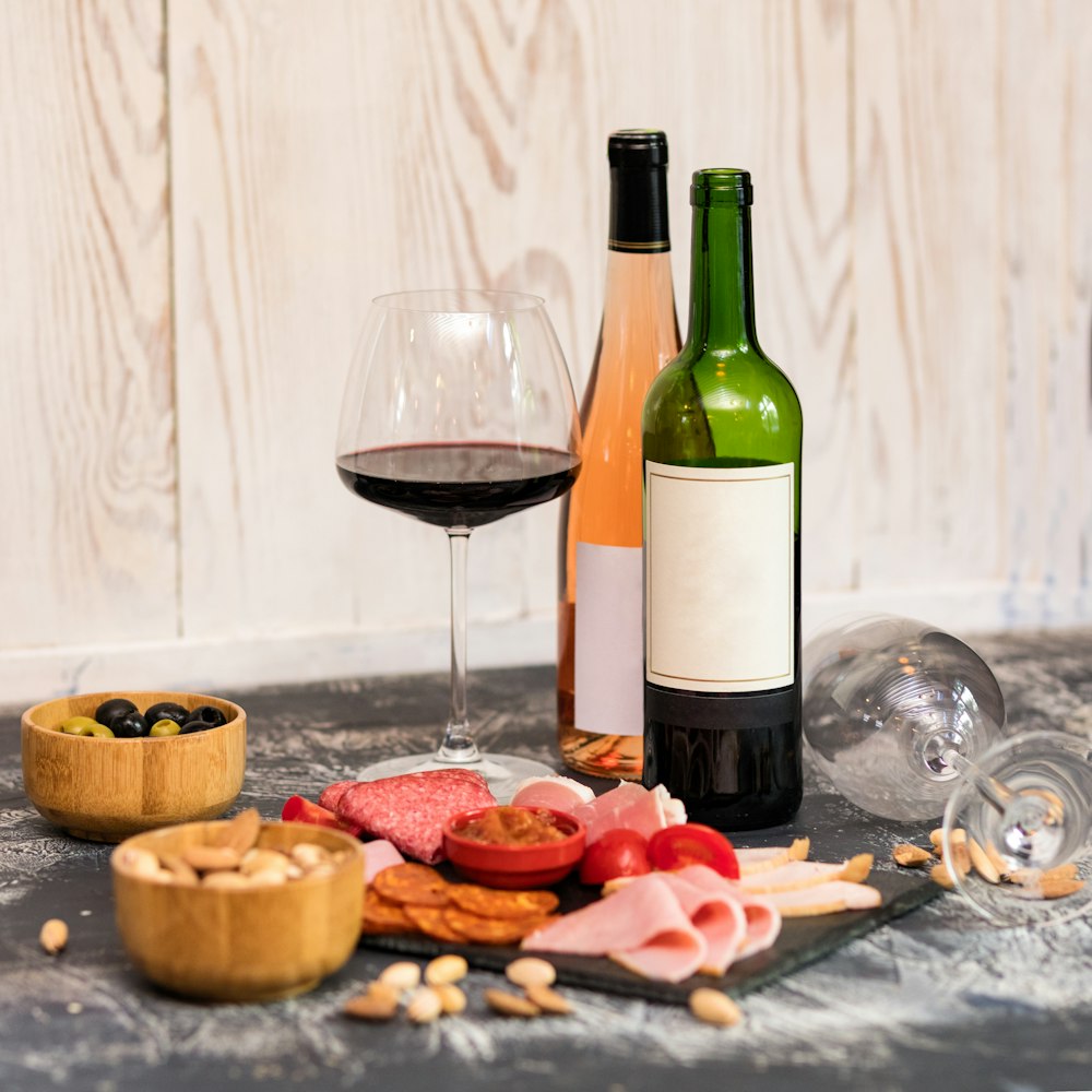 テーブルの上のワイングラスの横のワインボトル