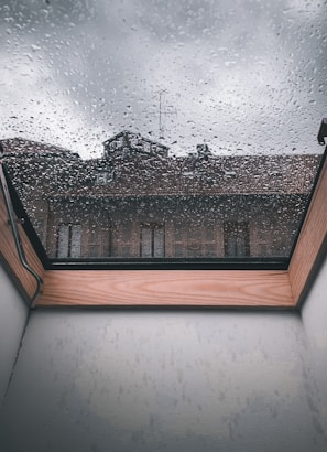 Close-up of a skylight before cleaning, showing hard-water stains and dirt buildup.
