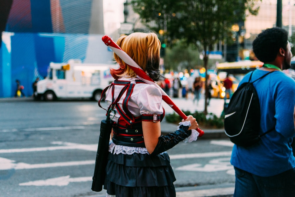 woman in red and black dress walking on street during daytime