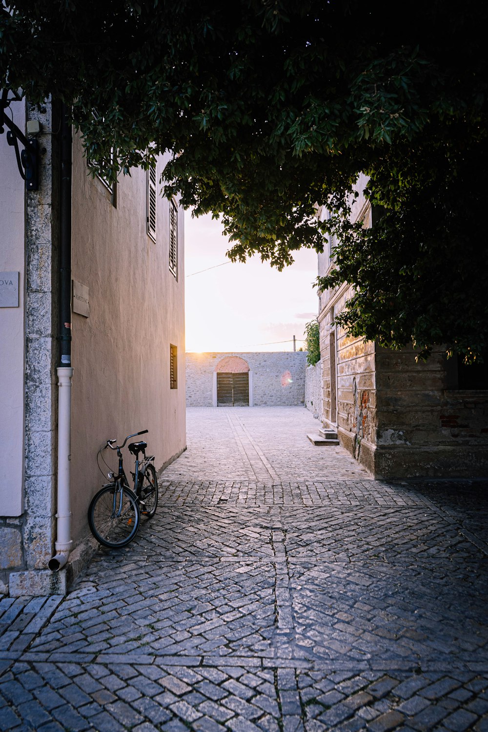 black bicycle parked beside white concrete wall during daytime