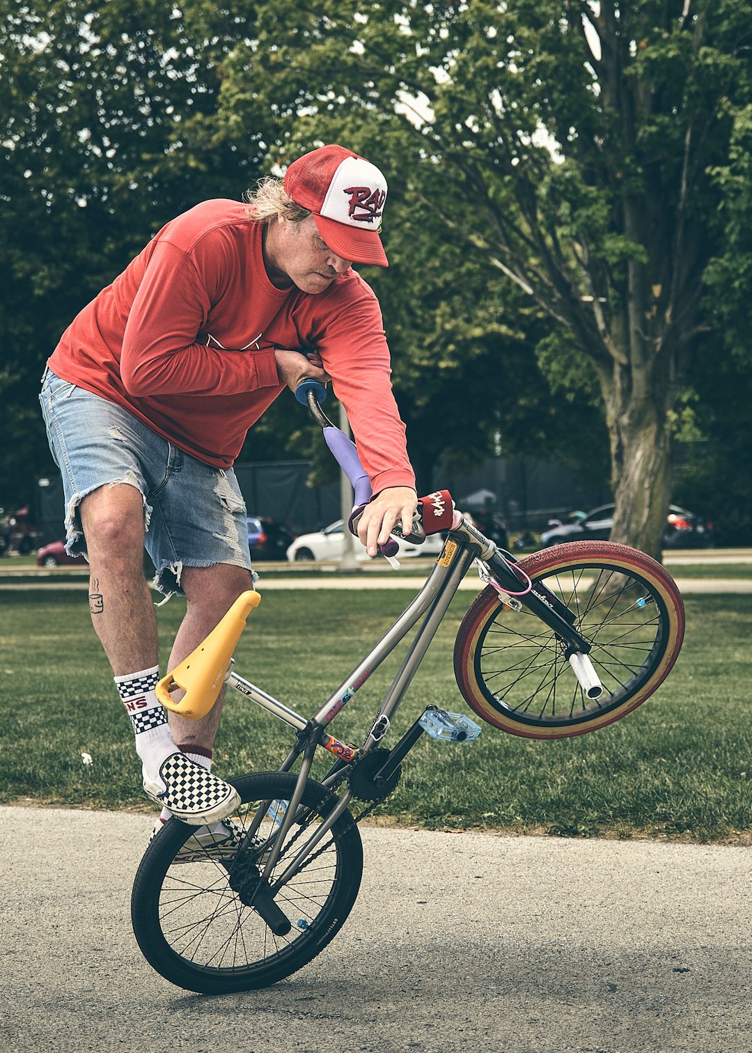 boy in red hoodie riding on bicycle during daytime