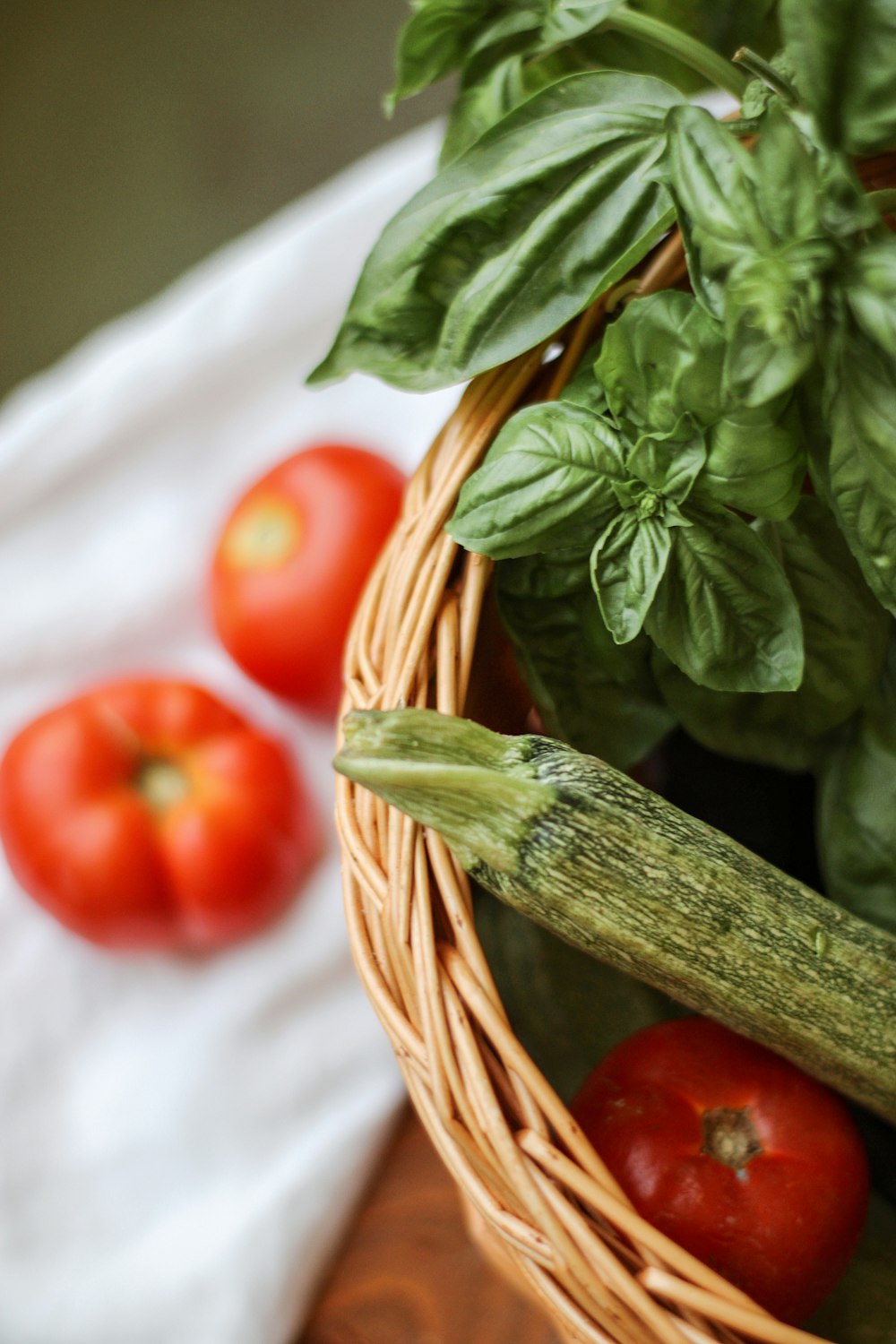 red tomato on brown woven basket