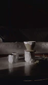 Handcrafted stoneware cups with natural glaze on wooden table in soft morning light.