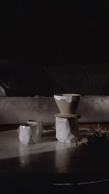 Handcrafted stoneware cups with natural glaze on wooden table in soft morning light.