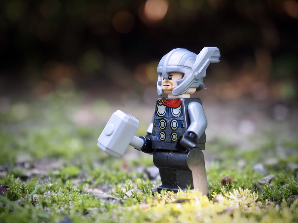 lego minifig on green grass during daytime