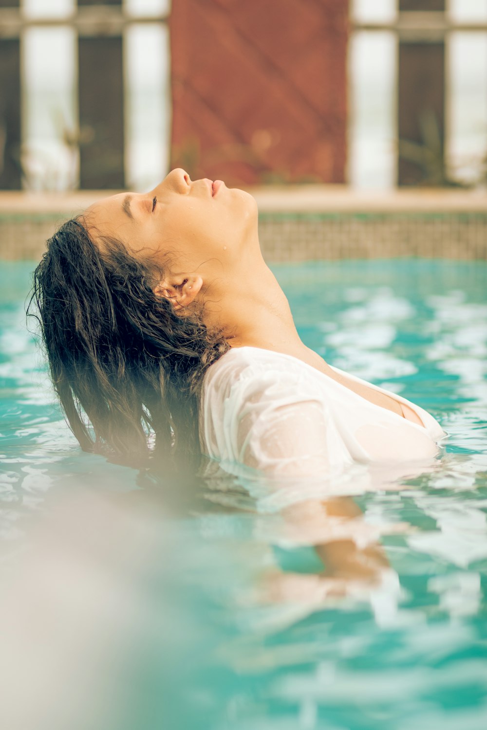 woman in white shirt in swimming pool during daytime