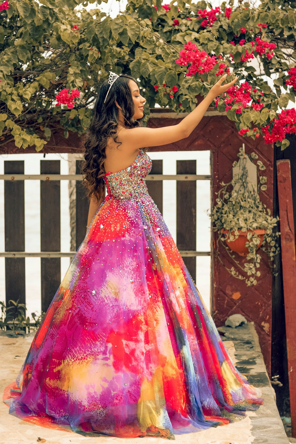 woman in red and pink tube dress holding red flowers