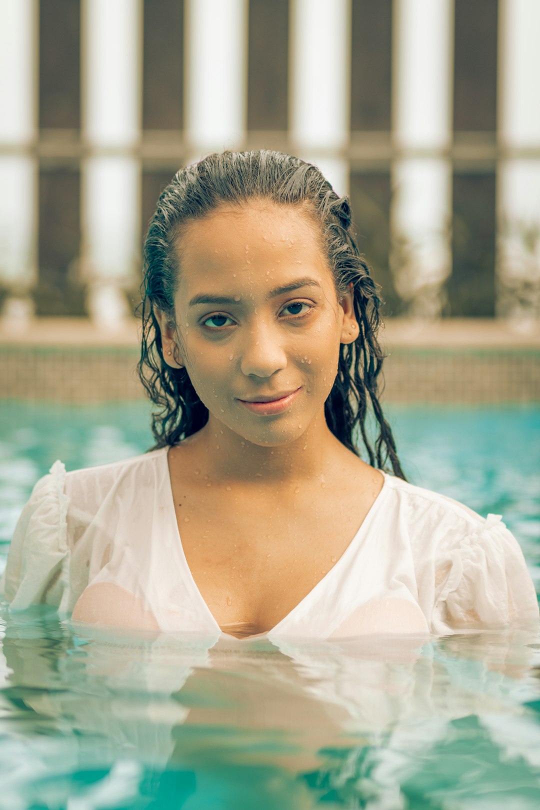 woman in white scoop neck shirt in swimming pool during daytime