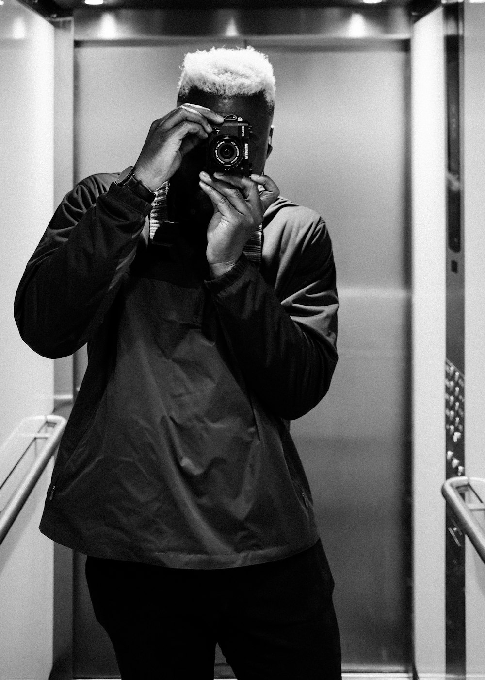 man in black jacket taking photo using black dslr camera
