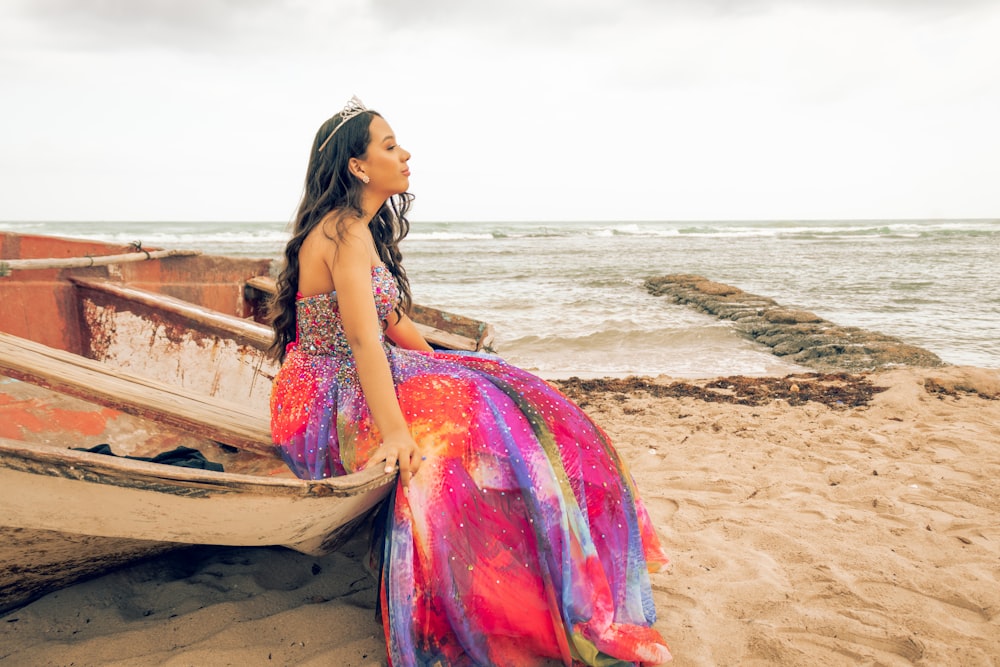 a woman sitting on a boat on the beach