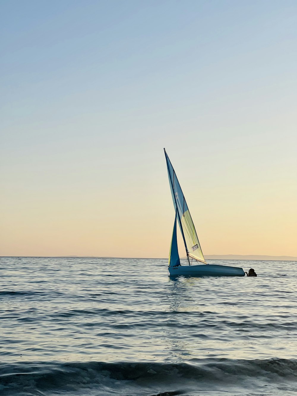 a small sailboat in the middle of the ocean