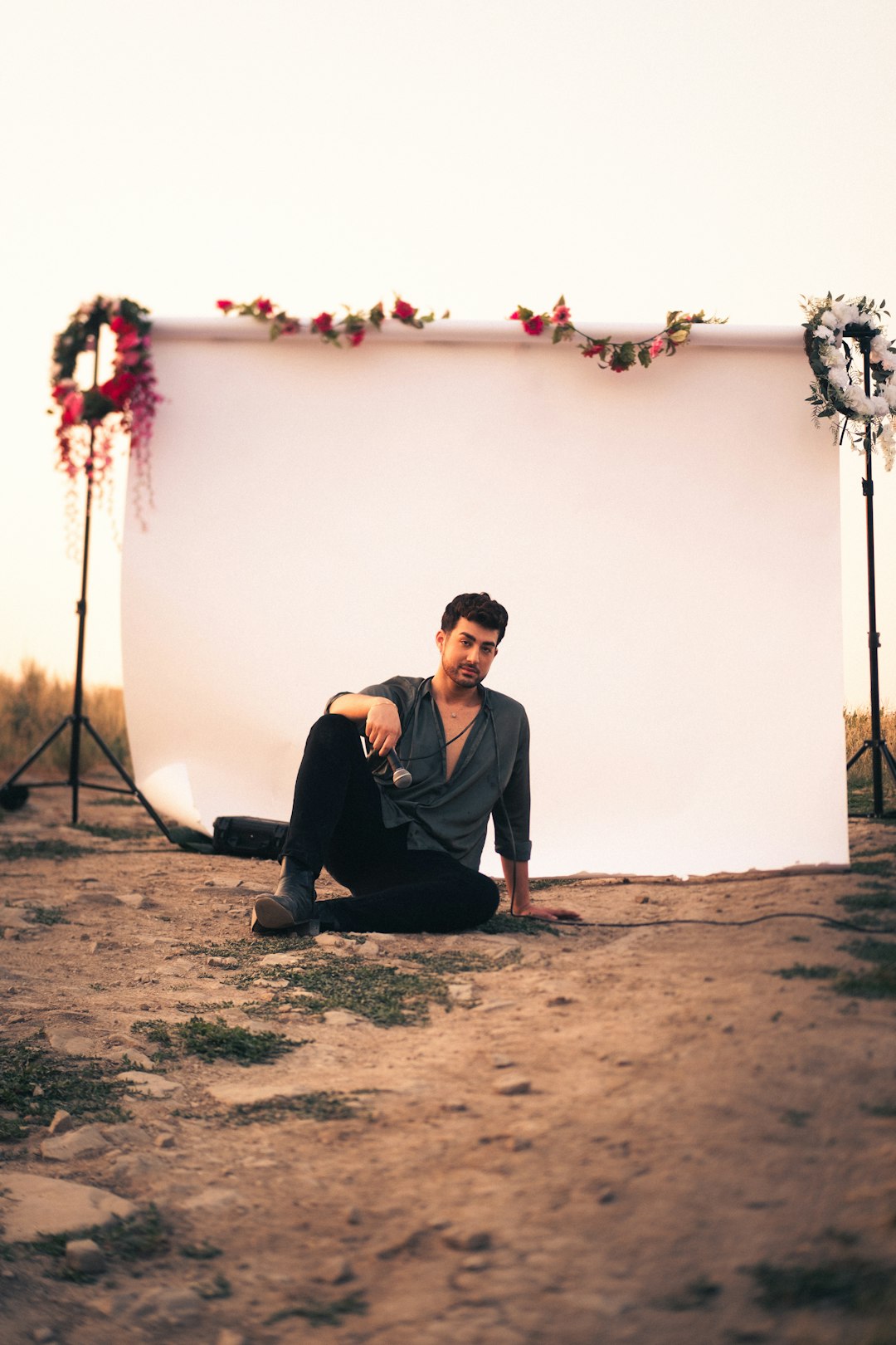 man in black crew neck t-shirt sitting on brown sand during daytime