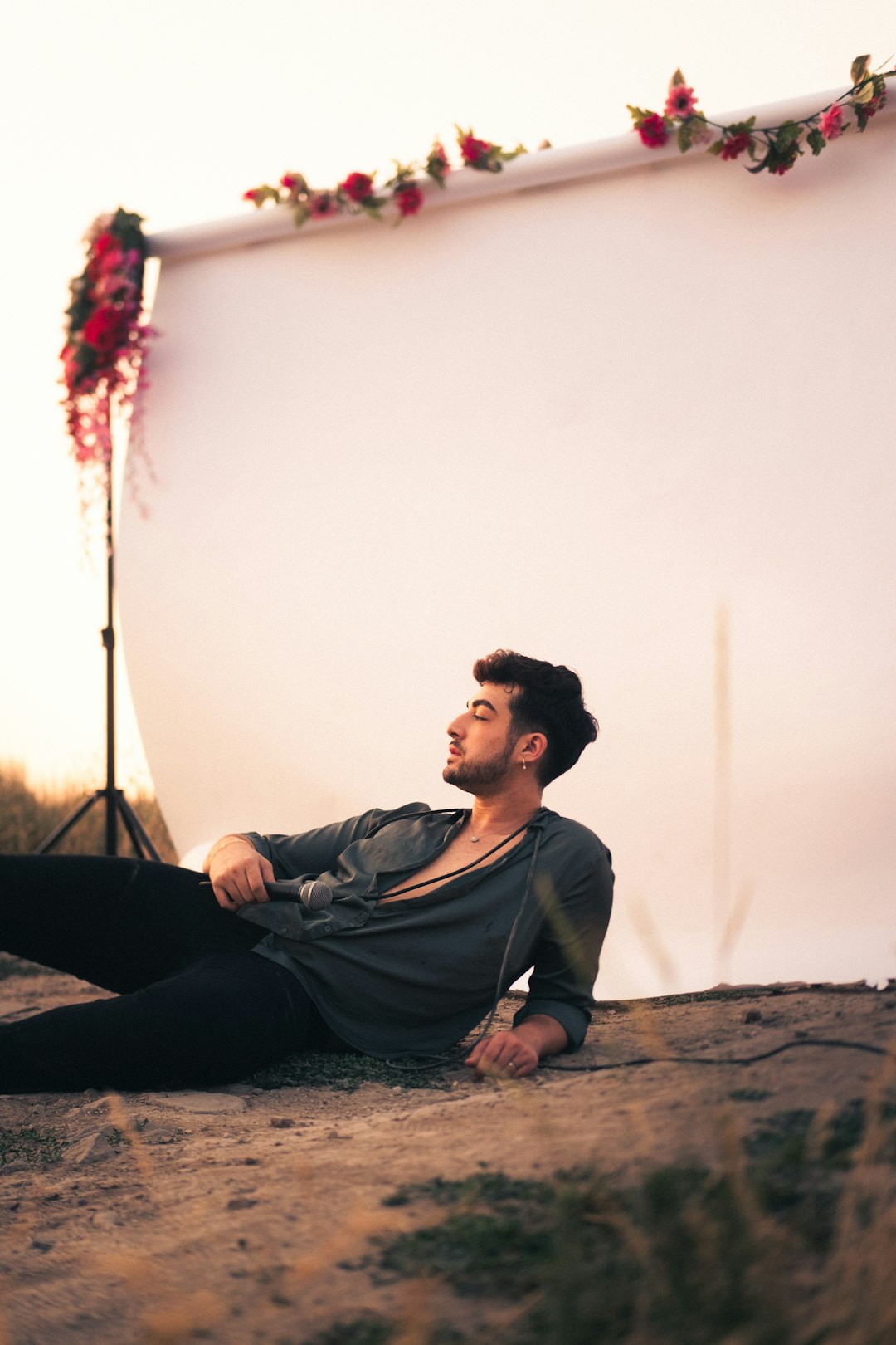 man in black long sleeve shirt sitting on brown rock