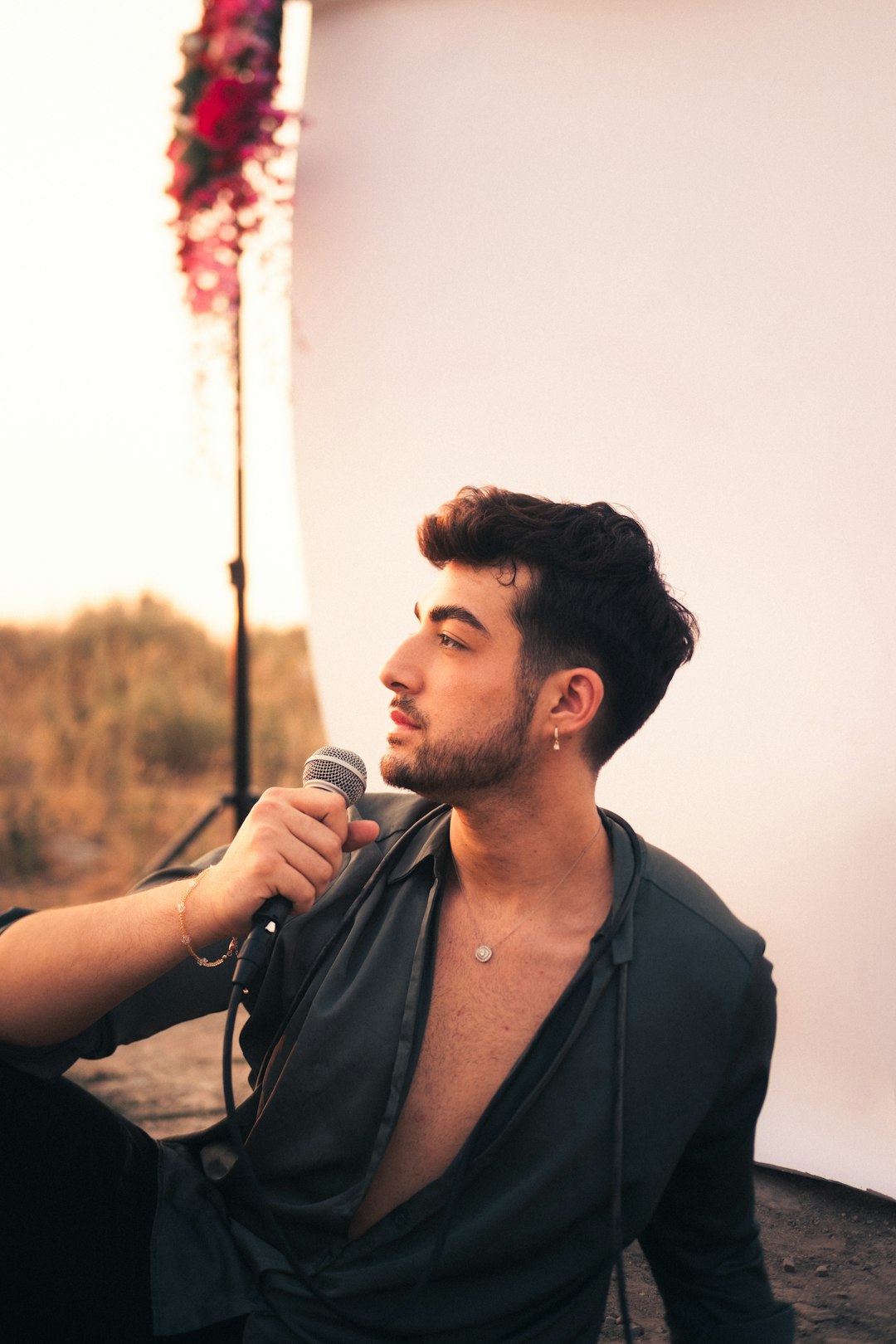 man in black polo shirt holding microphone