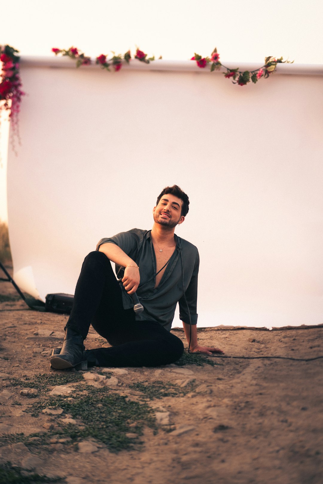 man in black jacket sitting on brown sand