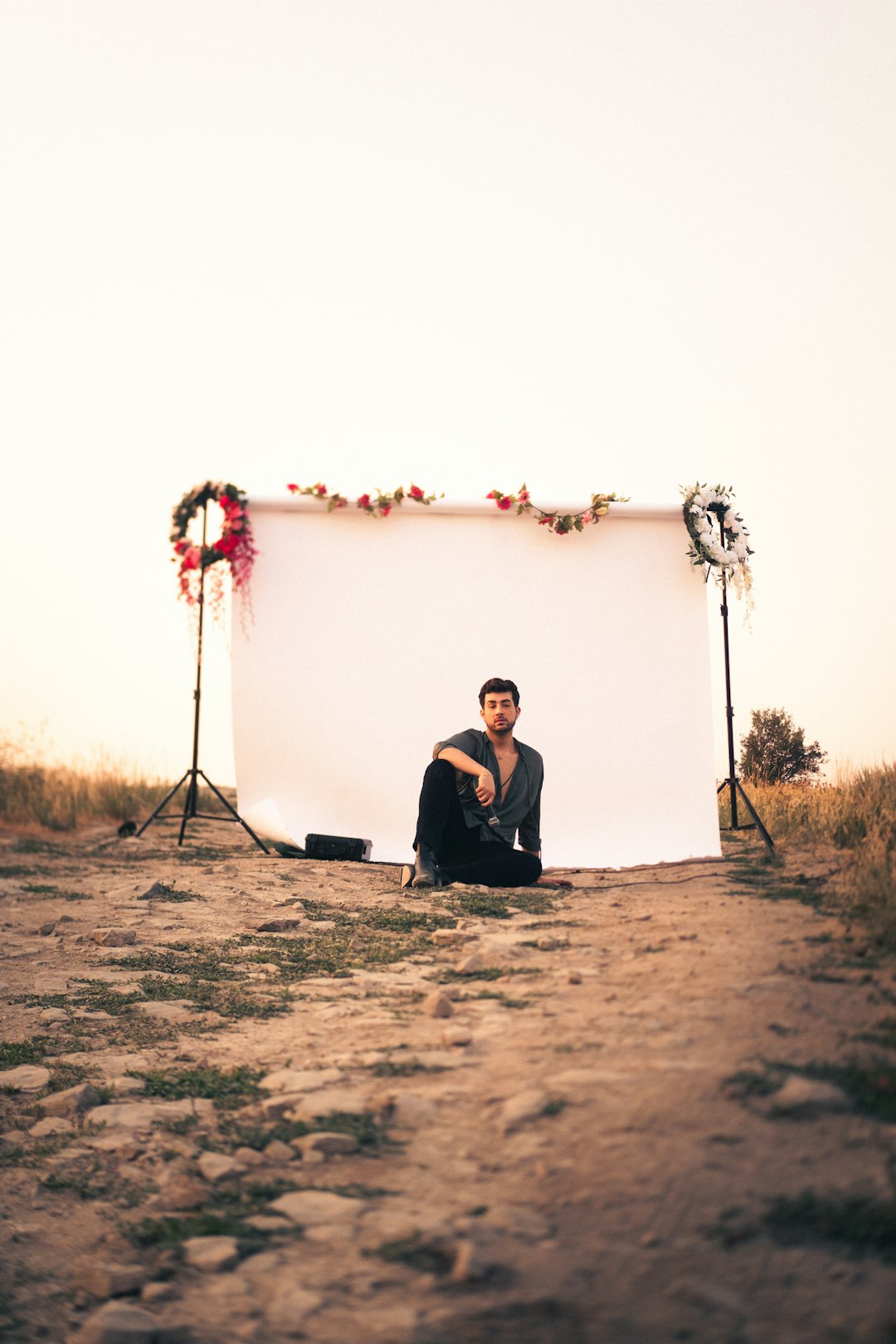 man in black jacket sitting on brown ground