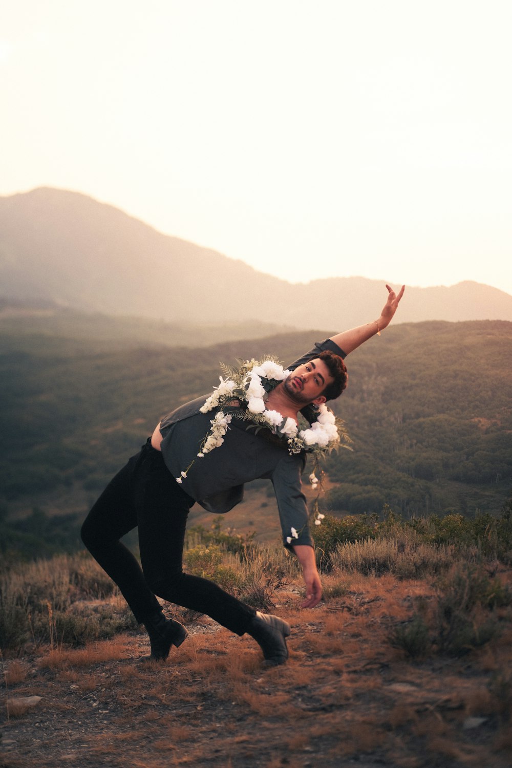 woman in black pants and black boots standing on green grass field during daytime