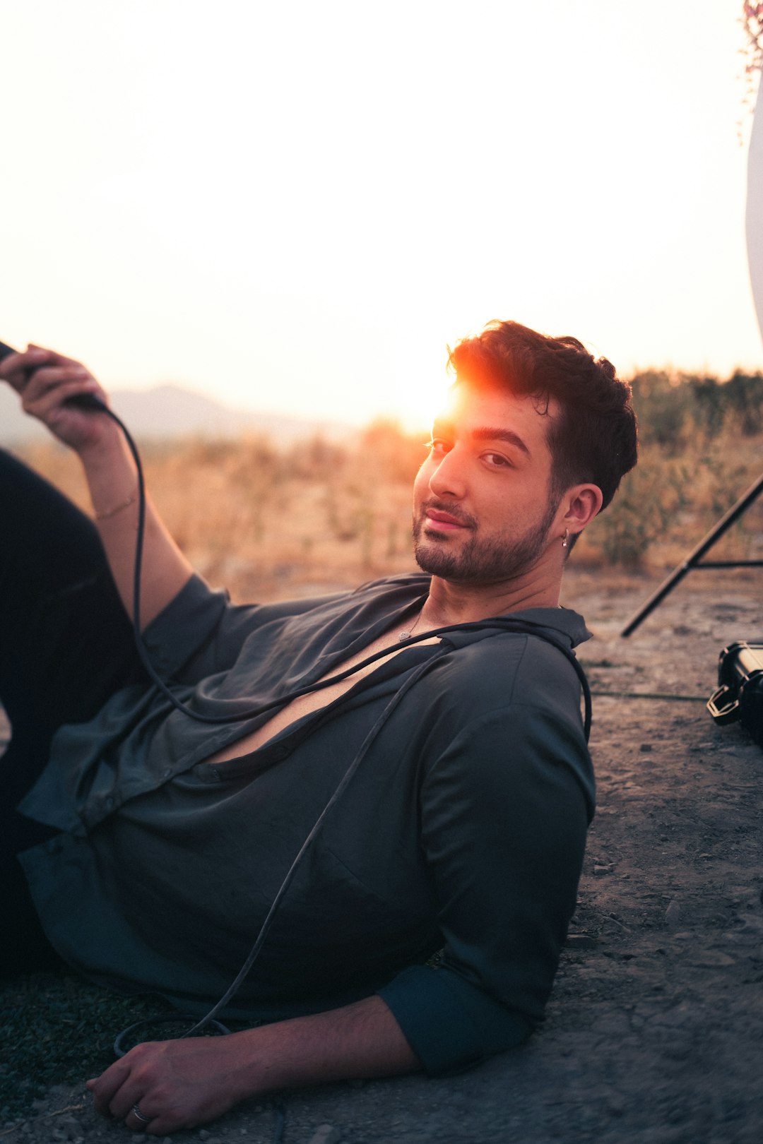 man in black jacket sitting on ground during daytime