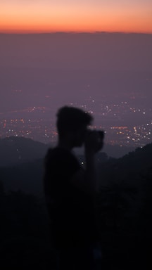 A candid shot of Erich Silalahi adjusting his camera lens during a cityscape shoot at dusk.