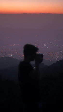 A cinematic photo of a photographer capturing a stunning Middle Eastern cityscape at dusk.