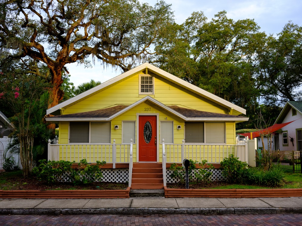 white and yellow wooden house near green trees during daytime