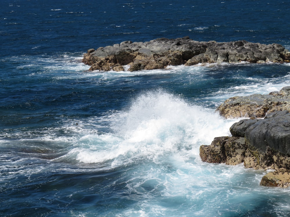 Onde dell'oceano che si infrangono sulla costa rocciosa durante il giorno