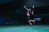 man in white and red crew neck t-shirt and black shorts playing basketball