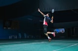 man in white and red crew neck t-shirt and black shorts playing basketball