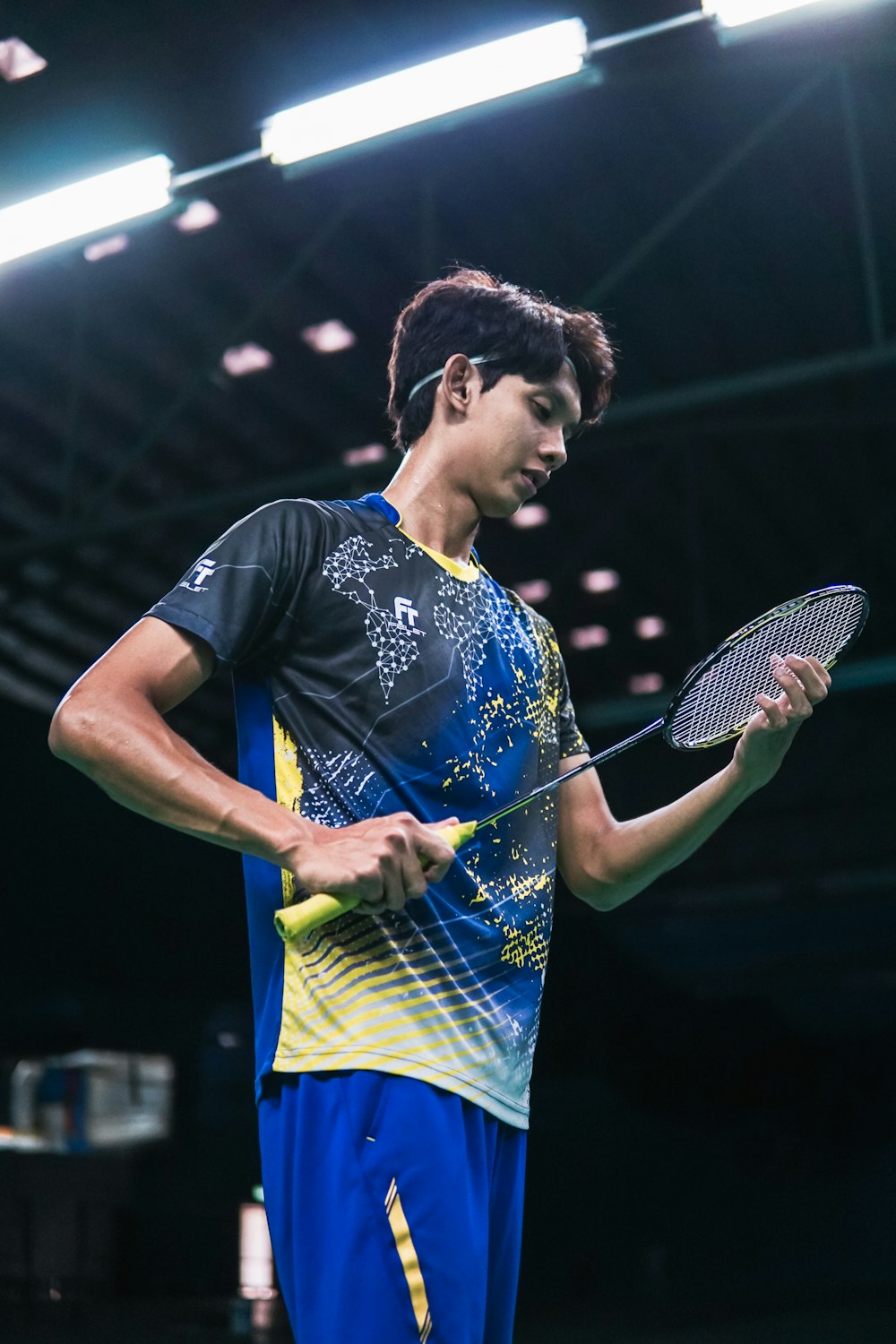 man in blue crew neck t-shirt holding black and white tennis racket