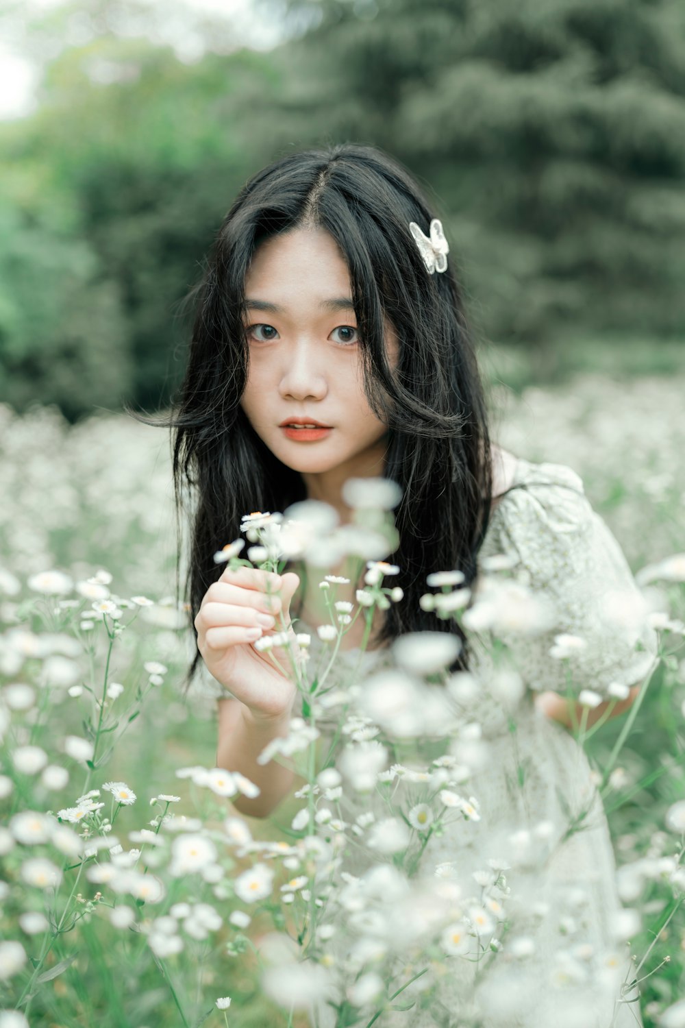 girl in white dress holding white flowers