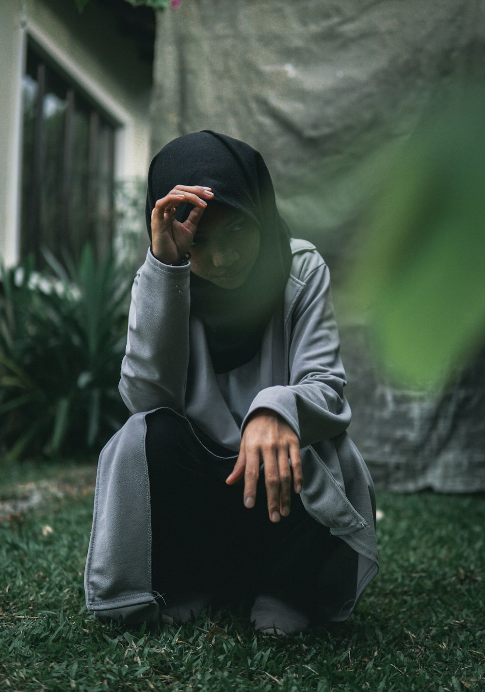 man in white thobe and black hijab sitting on green grass during daytime