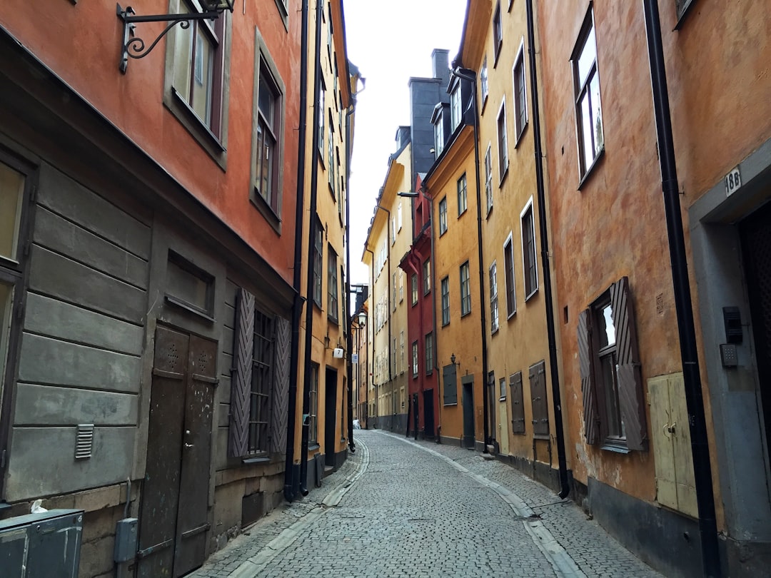 empty street between brown concrete buildings during daytime