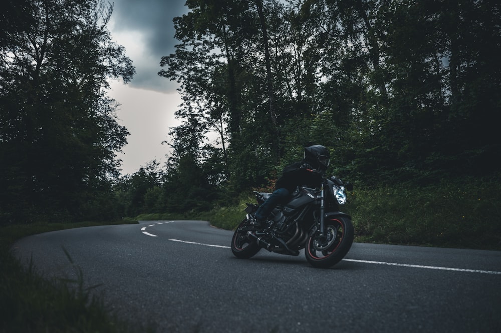 man in black motorcycle helmet riding motorcycle on road during daytime