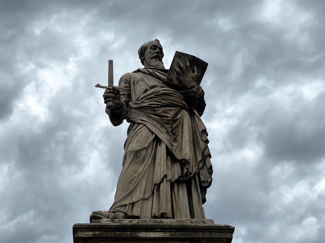 brown concrete statue under cloudy sky during daytime