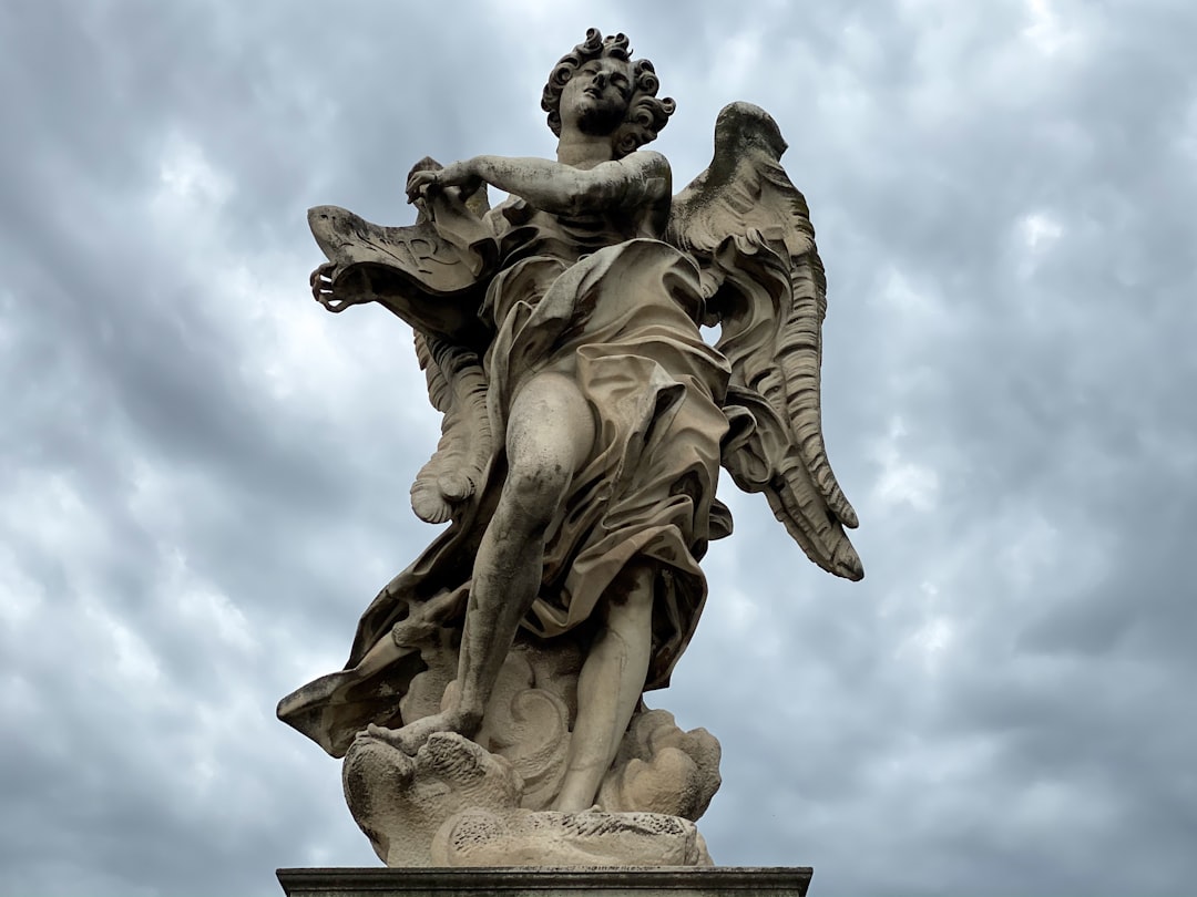 angel statue under white clouds during daytime