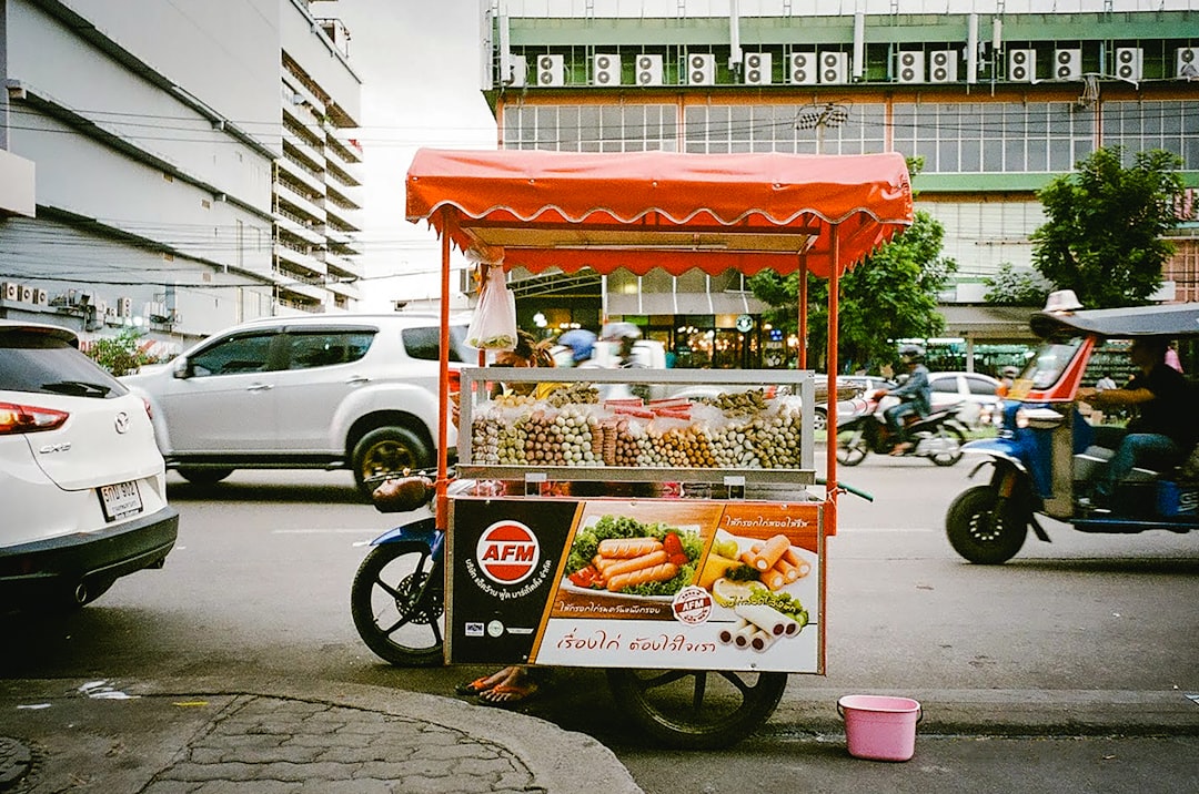red and black food cart on road during daytime