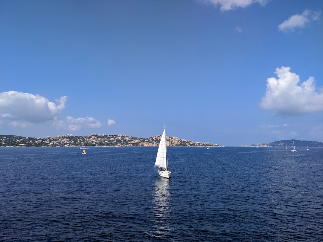 white sailboat on sea under blue sky during daytime