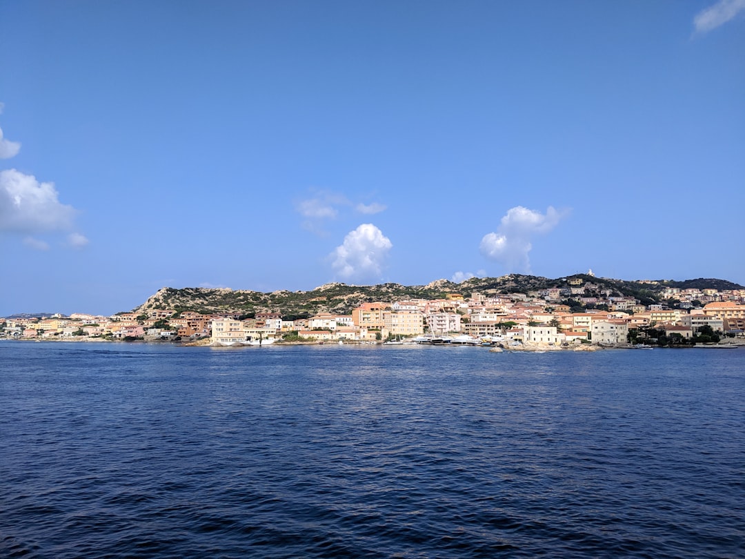 white and brown buildings near body of water under blue sky during daytime