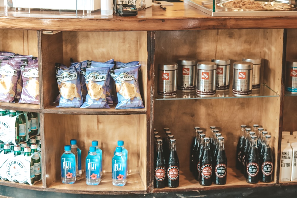 clear glass bottles on brown wooden shelf