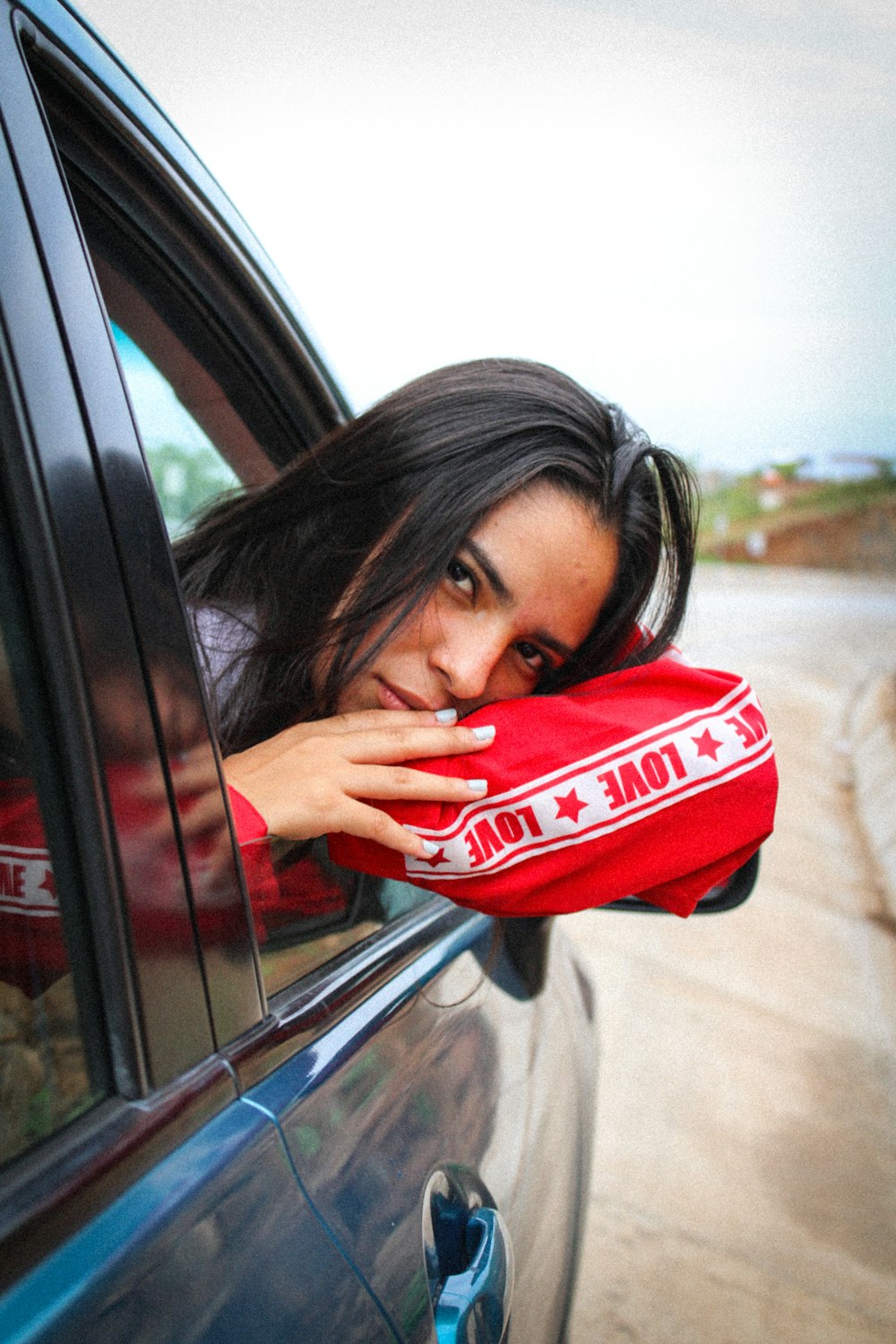woman in red and white adidas jacket covering her mouth