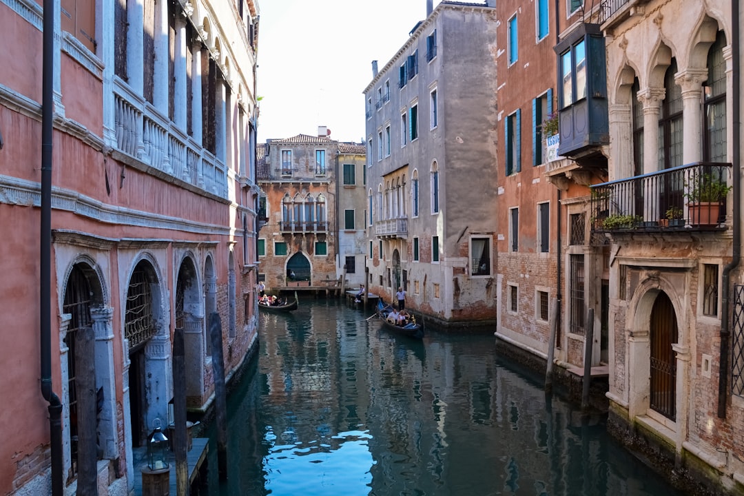 boat on river between buildings during daytime