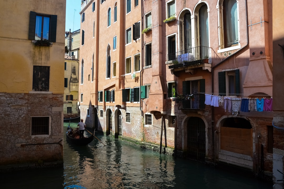 boat on river between buildings during daytime