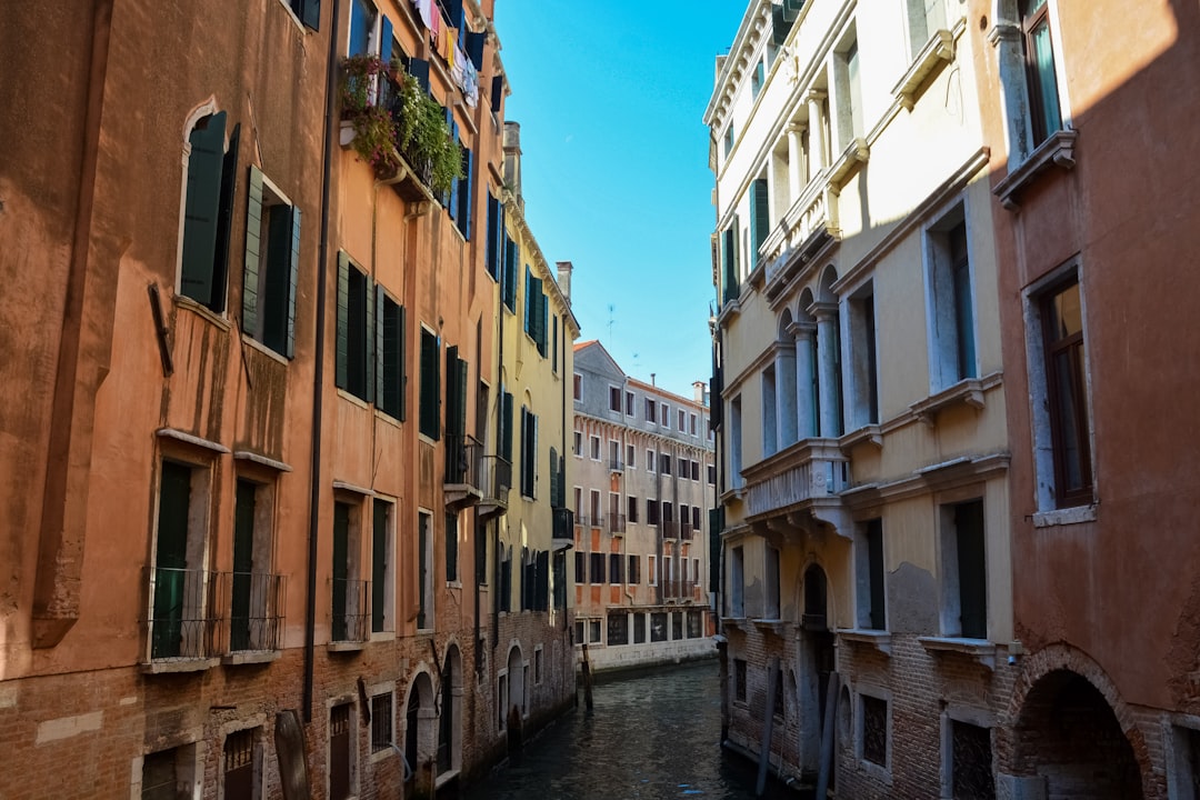 river between brown concrete buildings under blue sky during daytime