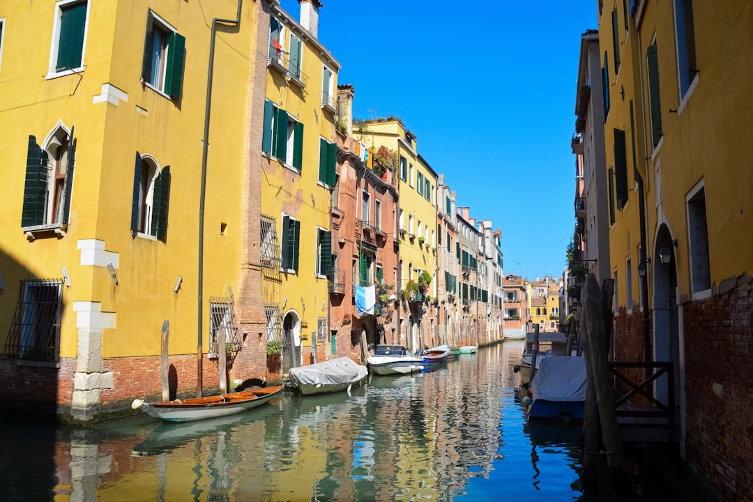 boat on river between buildings during daytime