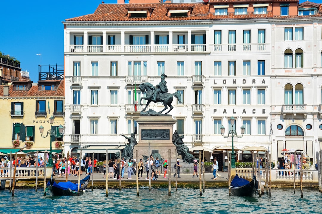 people riding on boat near white and brown concrete building during daytime