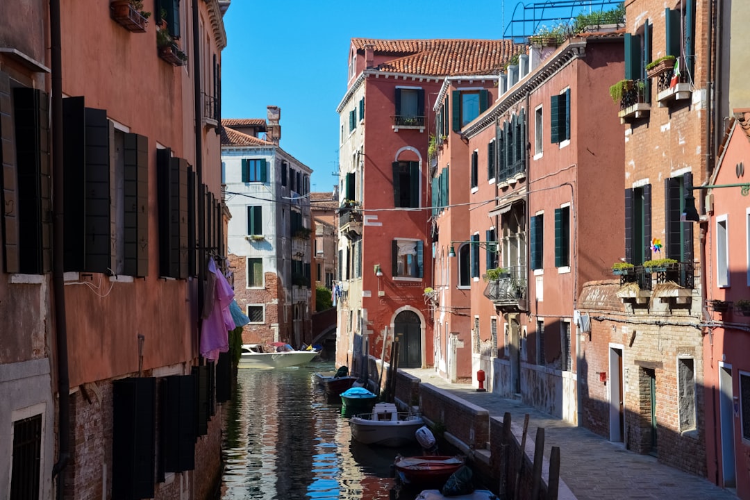 boat on river between buildings during daytime