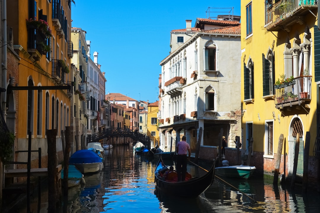 boat on river between buildings during daytime