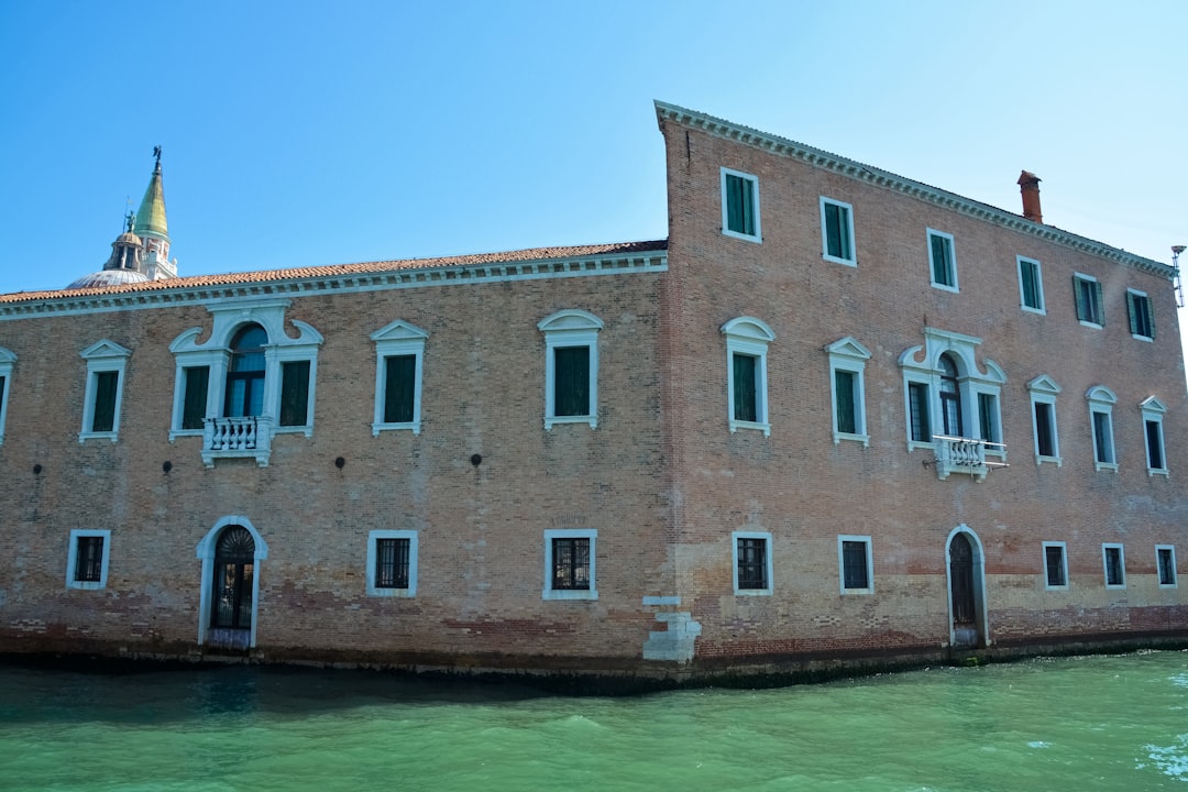 brown concrete building beside body of water during daytime