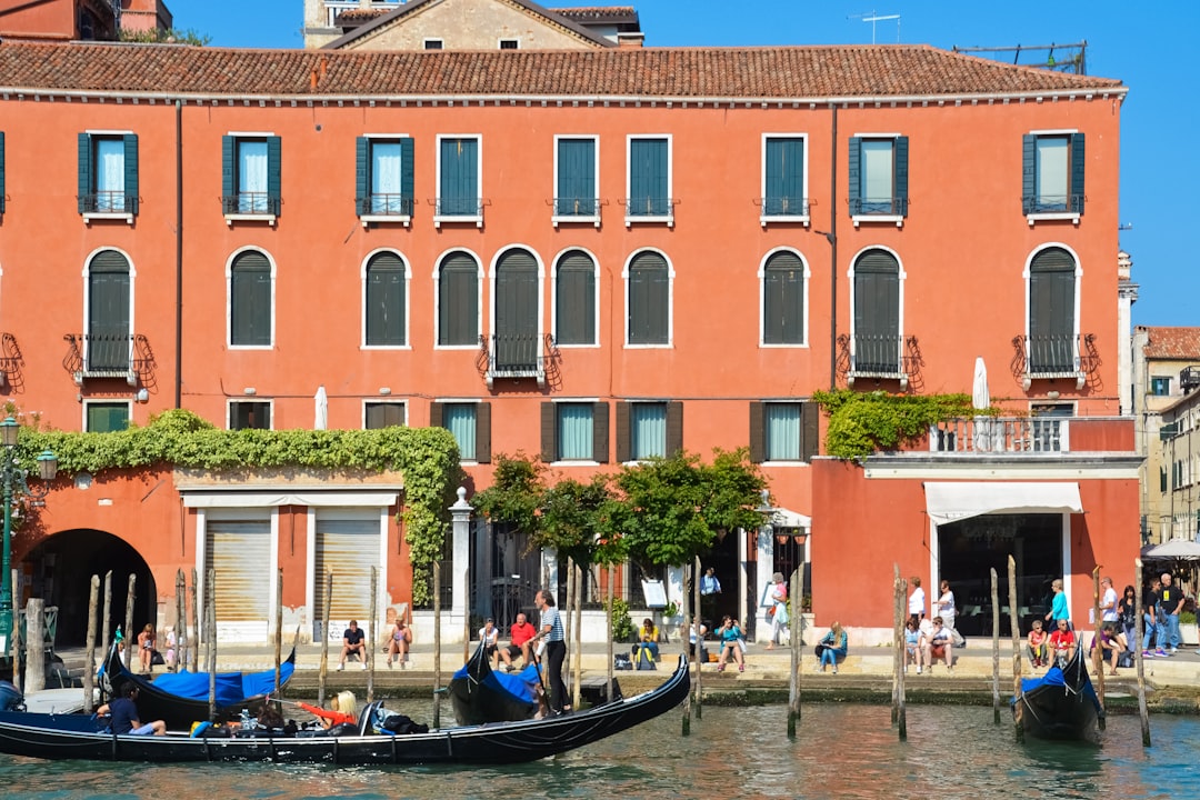 people riding on boat near brown concrete building during daytime